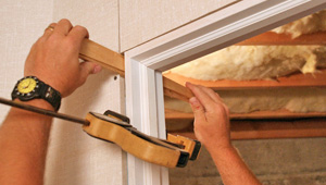 Installing trim and finishing touches to a remodeled basement in Waukegan, IL and WI